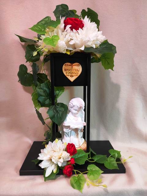 Dekoracja na Święto Wszystkich Świętych w środku aniołek z gipsu ze sztucznych kwiatów małe chryzantemy dodatkowo biała i czerwona piwonia